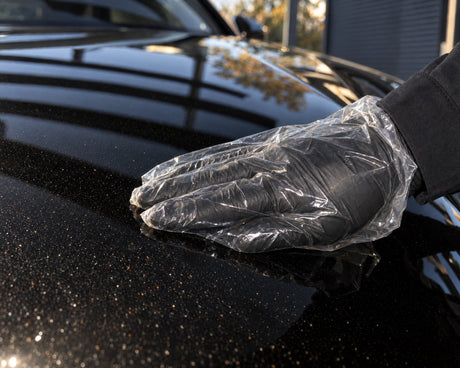 Detailing1 test du toucher sur l'Audi RS 5 noire — main dans un sachet sur la rouille volante et les retombées du capot