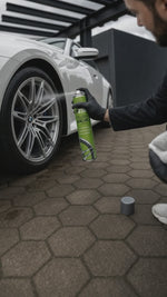 Detailing1 Hero-Stillleben: Felgenwachs wird auf die Alufelge eines weissen BMW gesprueht