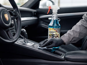 Kunststoff-Teufel wird mit Microfaser-Pad auf das schwarze Armaturenbrett-Plastik eines Porsche 911 aufgetragen